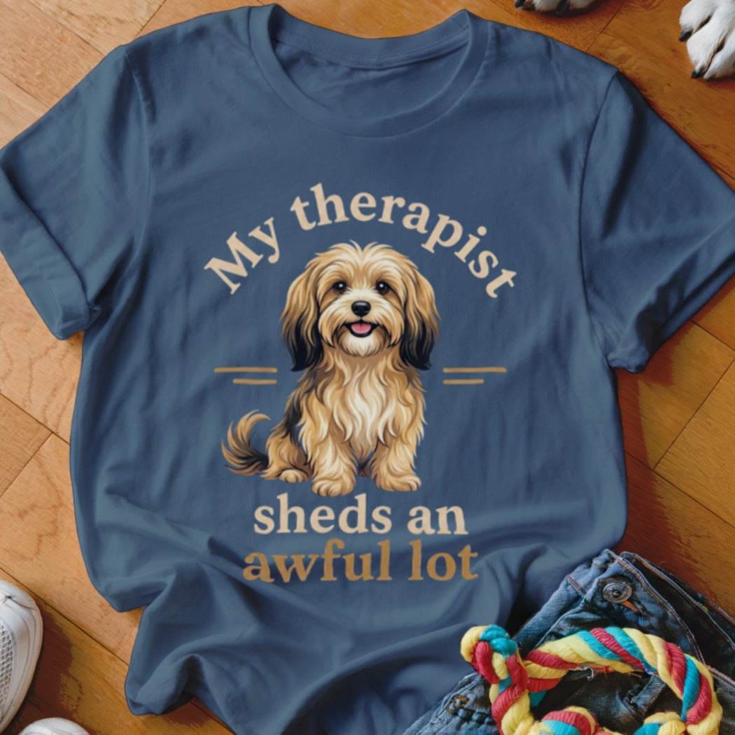 Blue t-shirt with illustration of a fluffy dog and text "My therapist sheds an awful lot."