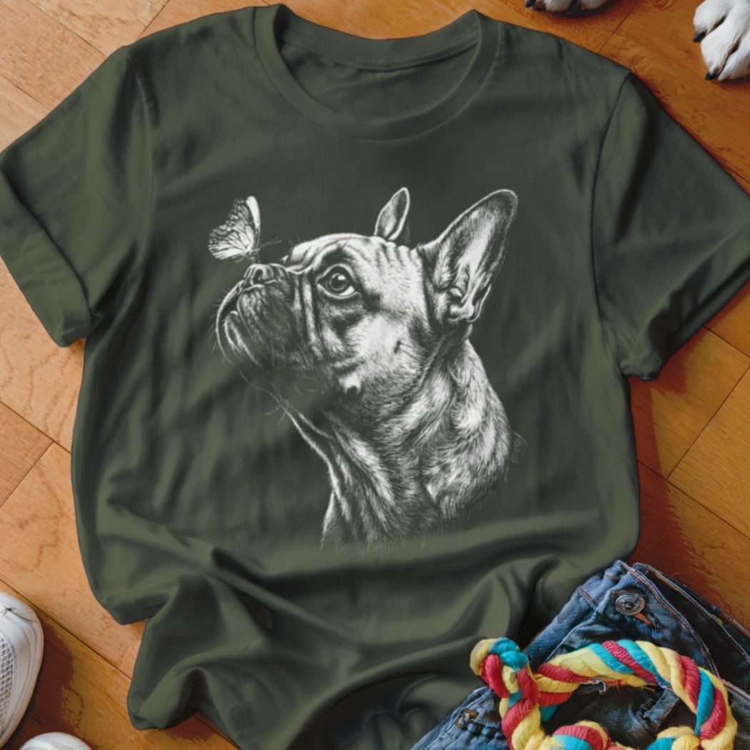 A dark green t-shirt featuring a white sketch of a French bulldog looking at a butterfly.