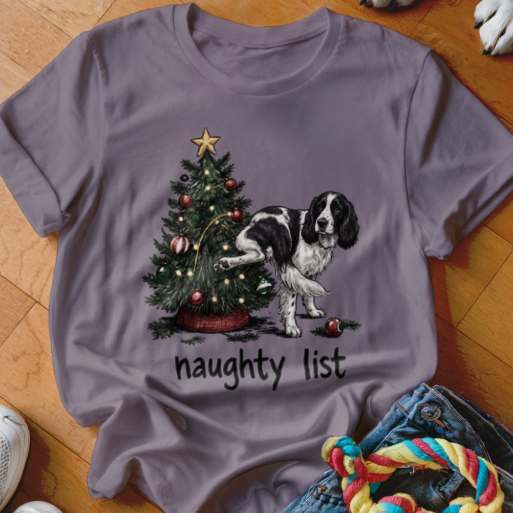 T-shirt with a black and white dog by a Christmas tree and "naughty list" text.