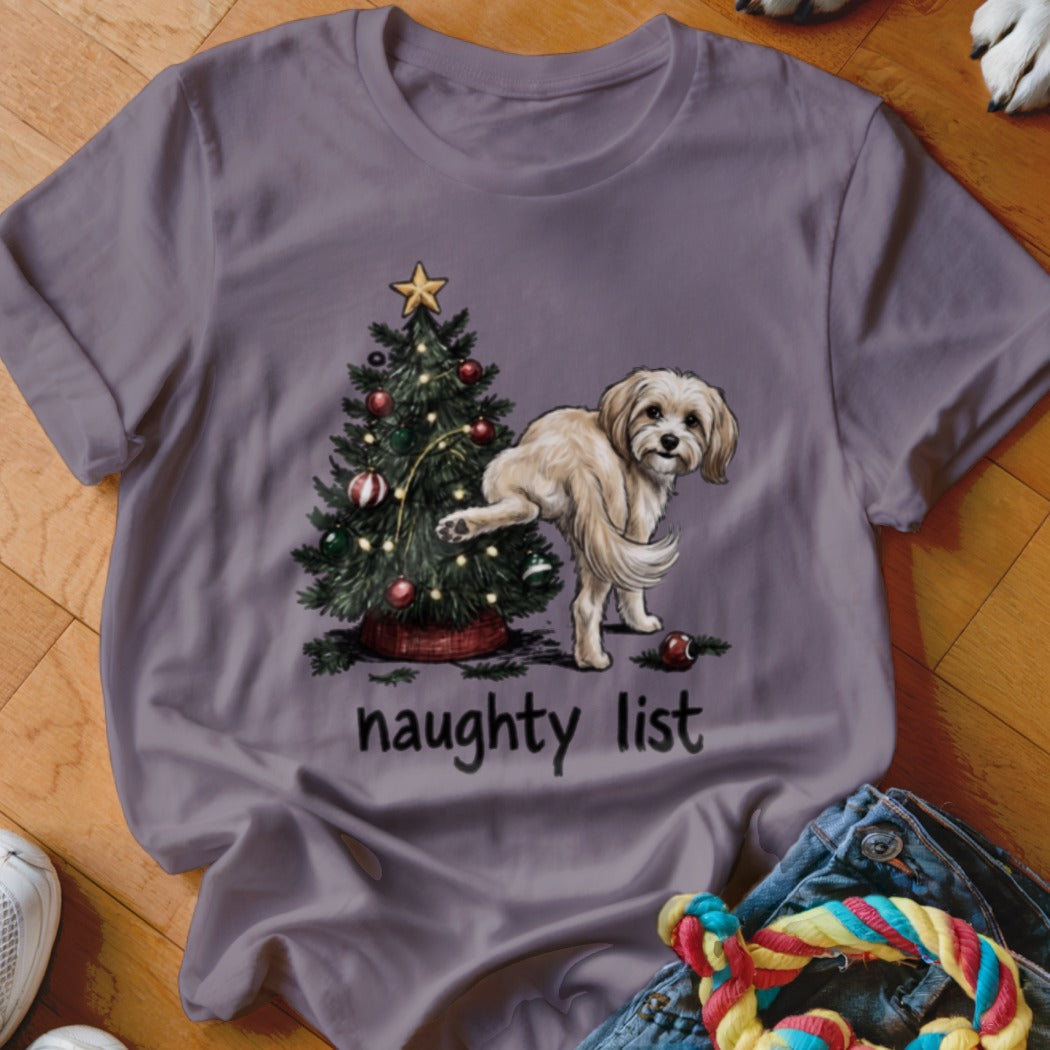 Fluffy dog next to Christmas tree with text "naughty list" below