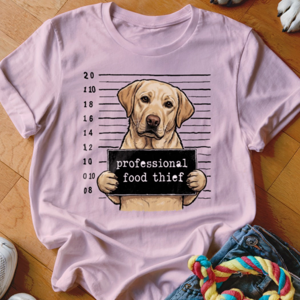 Labrador retriever mugshot with sign reading "professional food thief".