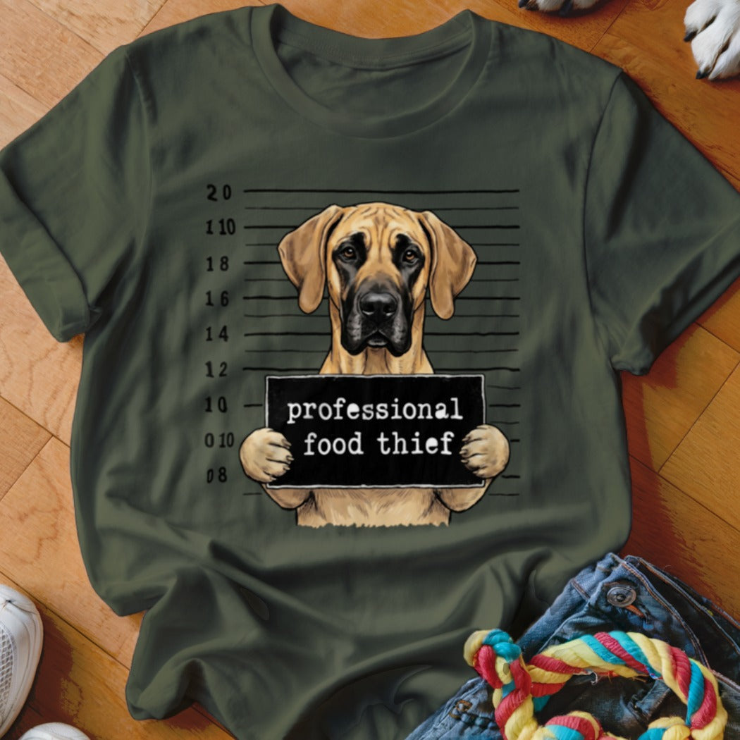 Great Dane with "professional food thief" sign in mugshot style.