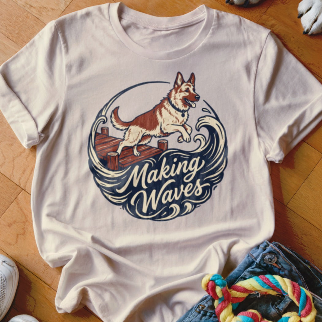 White t-shirt graphic of a dog jumping off a dock into waves with text "Making Waves."