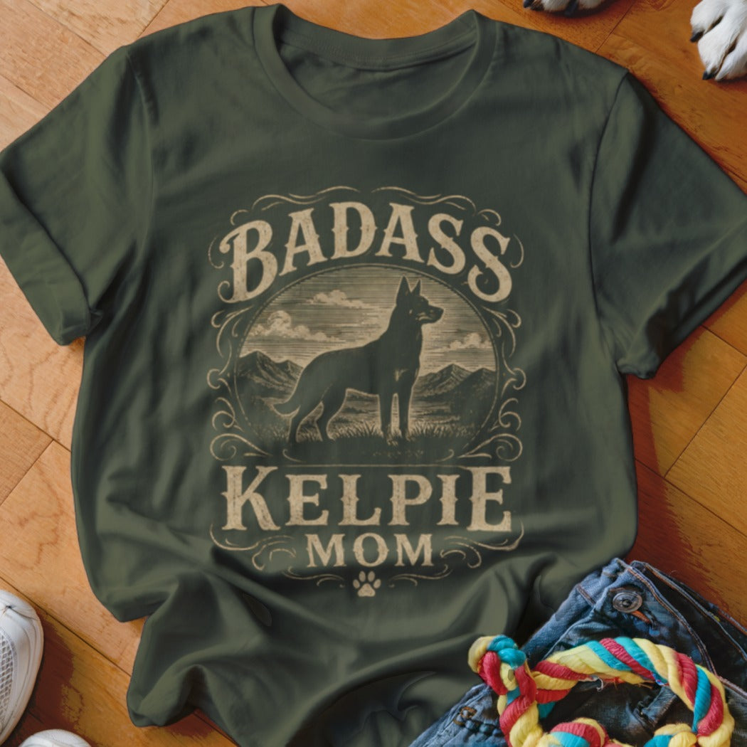 T-shirt with "Badass Kelpie Mom" text and a dog silhouette in a circular frame.