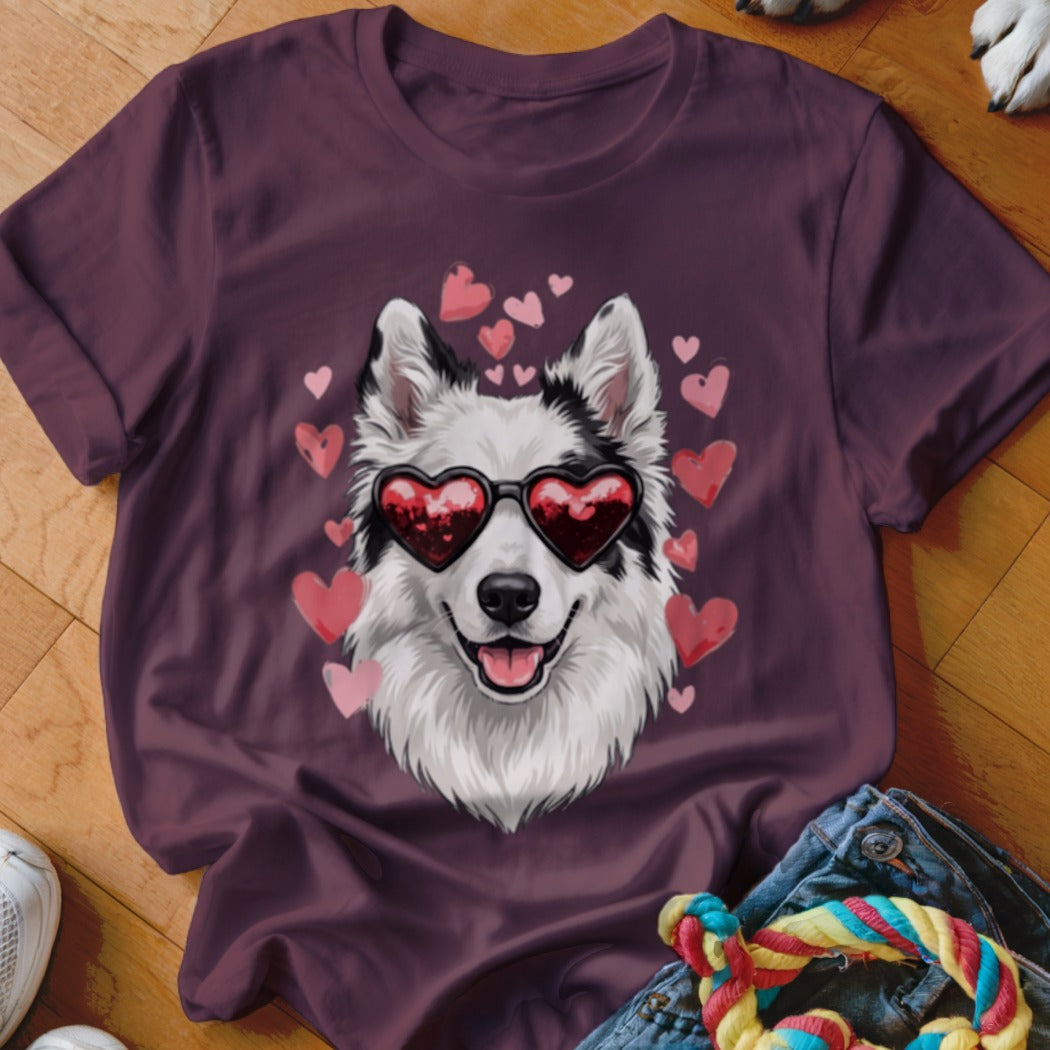 A dark purple t-shirt featuring a graphic of a white dog wearing heart-shaped sunglasses, surrounded by pink hearts.