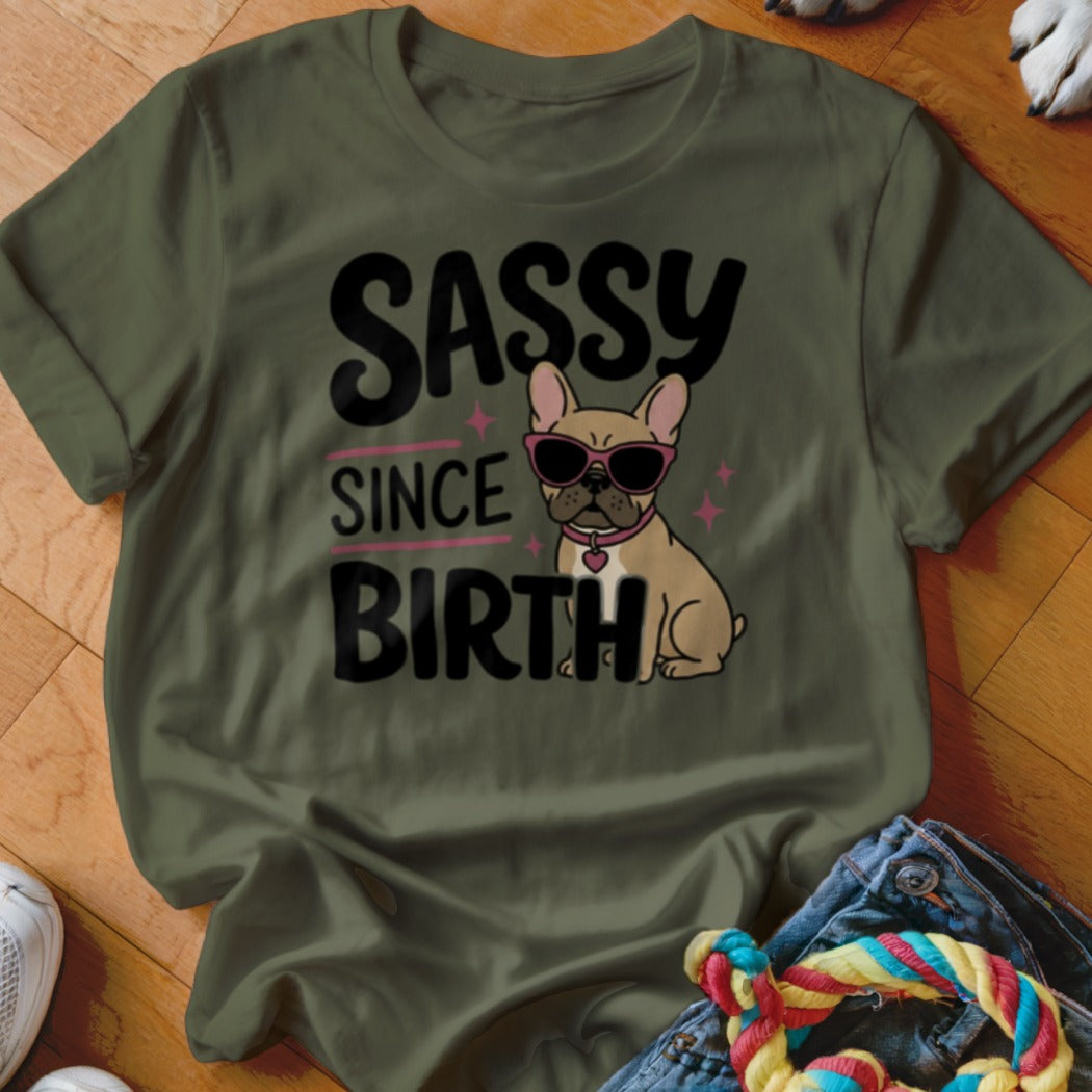 Olive green t-shirt with "SASSY SINCE BIRTH" text and a French bulldog wearing sunglasses.