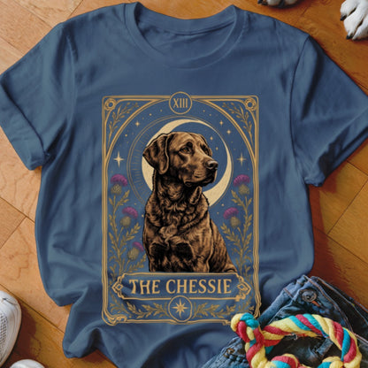 A blue t-shirt featuring a tarot card graphic of a Chesapeake Bay Retriever and the text The Chessie.