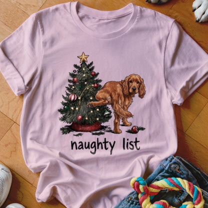 Pink t-shirt with a Christmas tree and a dog lifting its leg, text says "naughty list."