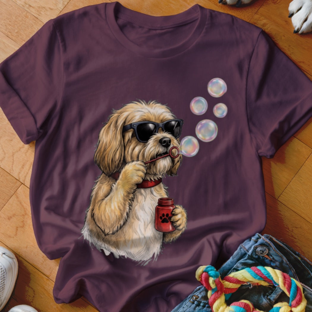 A dark purple t-shirt features a graphic of a shaggy blonde dog wearing sunglasses and blowing bubbles.