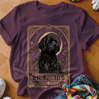 Dark plum t-shirt featuring a tarot-style graphic of a black dog and the text The Portie.