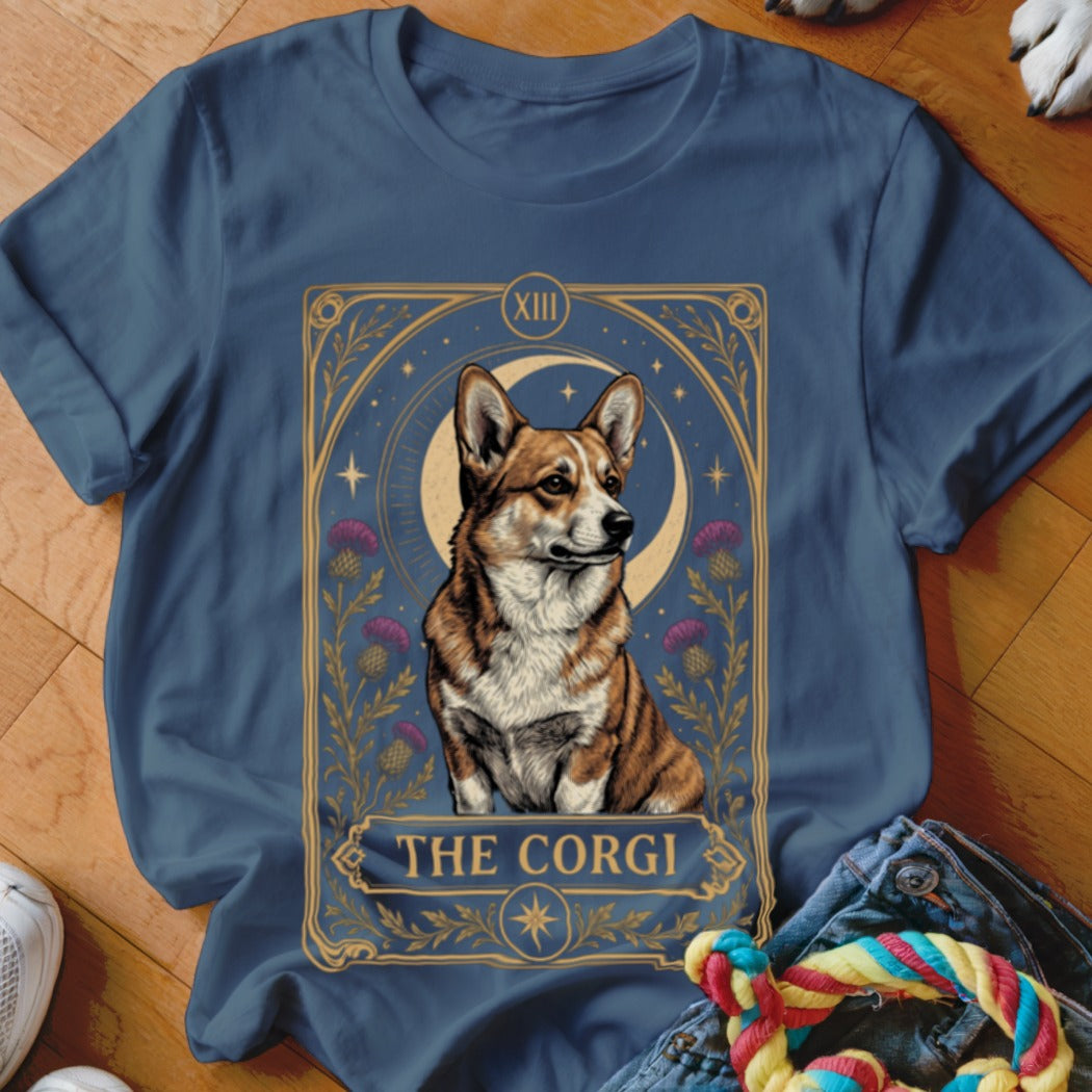 A blue crewneck t-shirt featuring a tarot card graphic of a corgi, moon, and thistles.