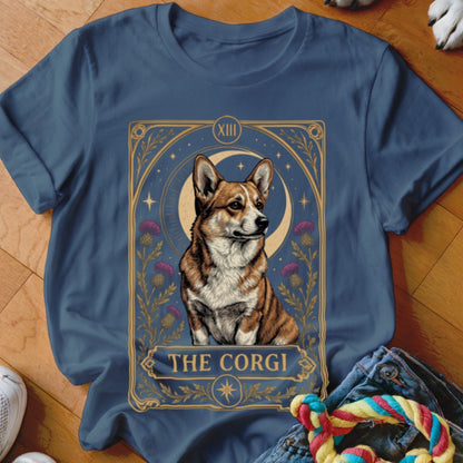A blue crewneck t-shirt featuring a tarot card graphic of a corgi, moon, and thistles.