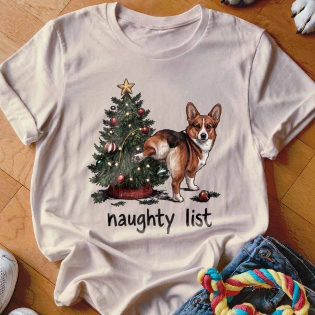 Cream t-shirt with a corgi and Christmas tree graphic that reads "naughty list."