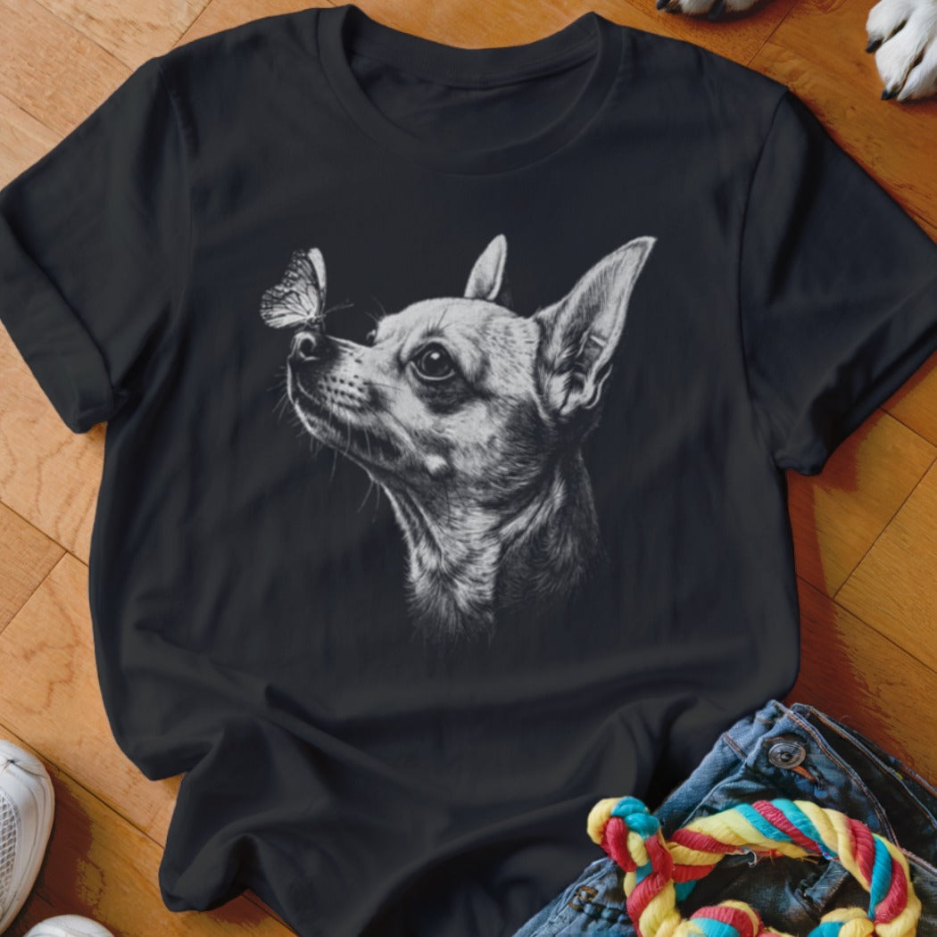 A black crewneck t-shirt featuring a white sketch of a chihuahua looking at a butterfly.