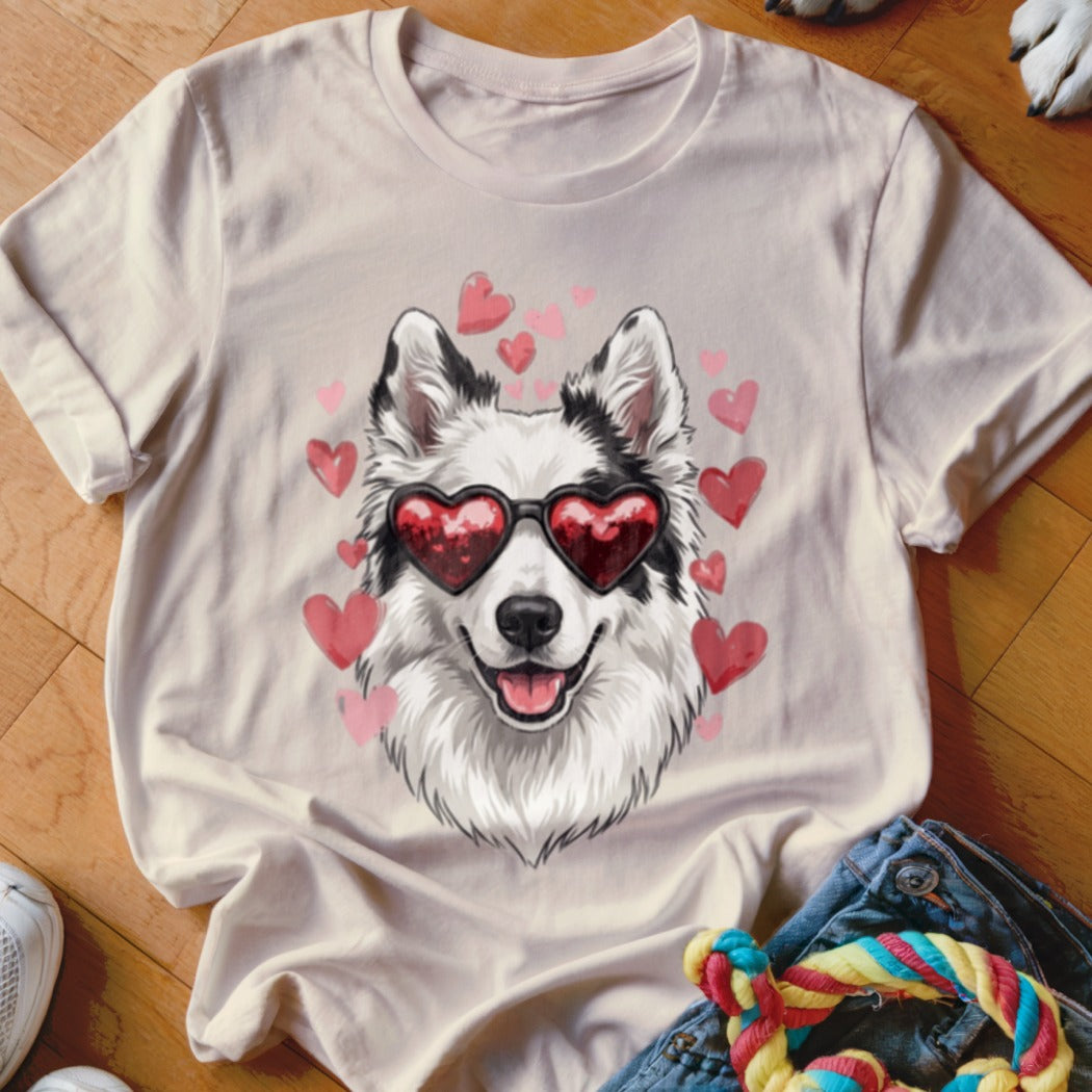 Light pink t-shirt featuring a graphic of a smiling dog wearing heart-shaped sunglasses surrounded by floating hearts.