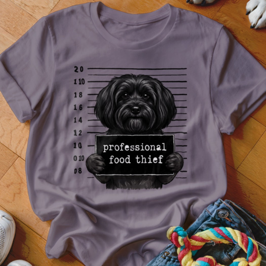 Black dog mugshot with "professional food thief" sign and height markings.