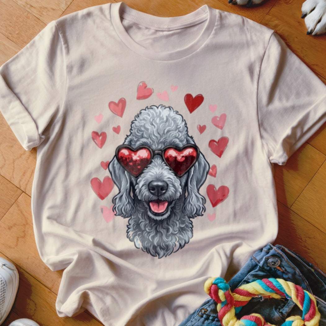 A light pink crewneck t-shirt featuring a graphic of a grey poodle wearing heart-shaped sunglasses, surrounded by pink and red hearts.