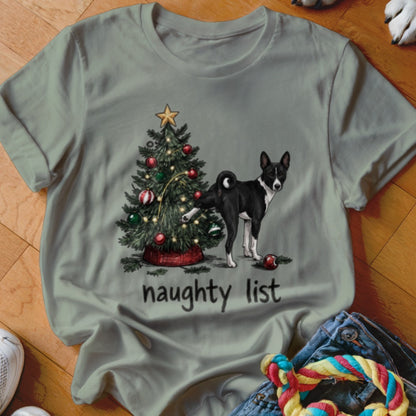 Sage green t-shirt with a graphic of a dog lifting its leg on a Christmas tree and the text "naughty list".