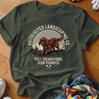 Green t-shirt with a dog digging dirt, reads "Unsolicited Landscaping Co."