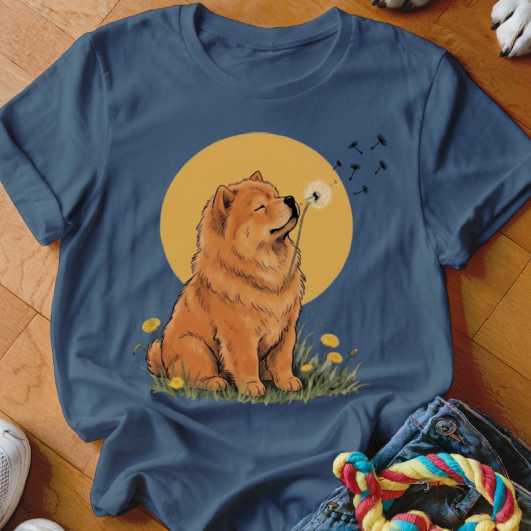 A blue t-shirt featuring a graphic of a fluffy orange dog blowing a dandelion.