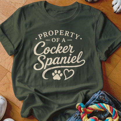 Green t-shirt with "Property Of A Cocker Spaniel" text and paw print heart.