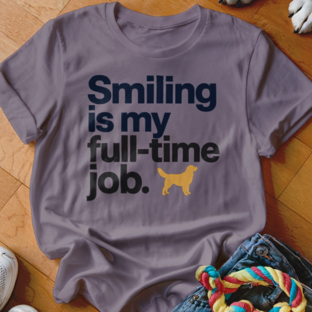 A purple t-shirt featuring the text "Smiling is my full-time job" with a golden retriever silhouette.