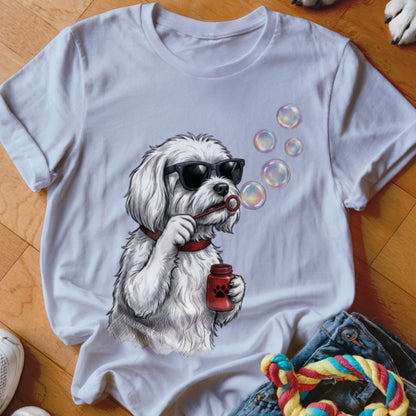 A white t-shirt featuring a graphic illustration of a white dog wearing sunglasses and blowing soap bubbles.