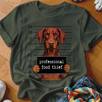 Dog mugshot graphic with "professional food thief" text on dark green t-shirt.