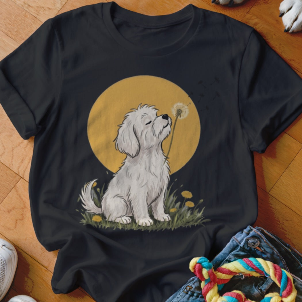 Black t-shirt featuring a graphic of a white fluffy dog smelling a dandelion against a yellow sun.