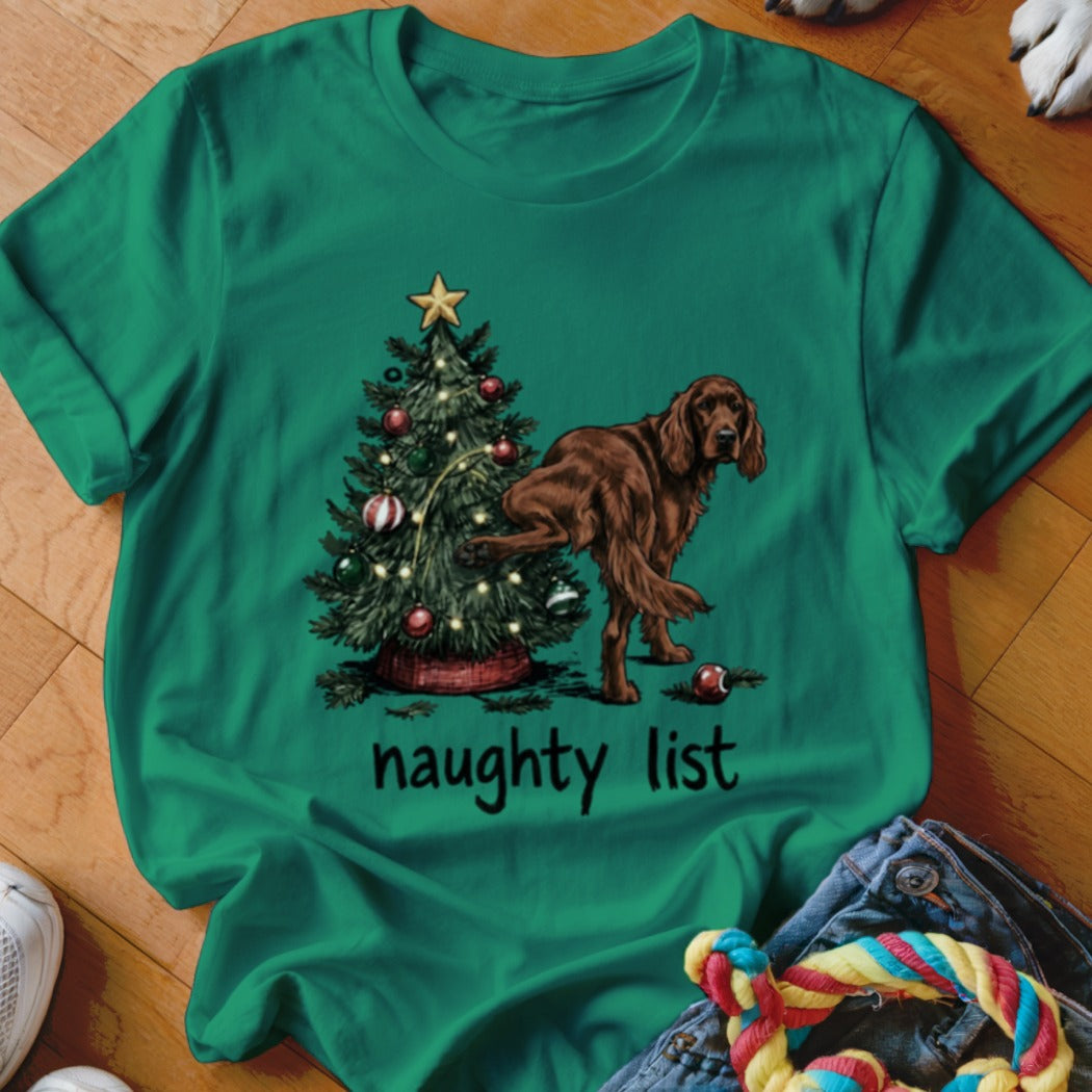 Green t-shirt with a brown dog lifting its leg on a Christmas tree with text "naughty list".