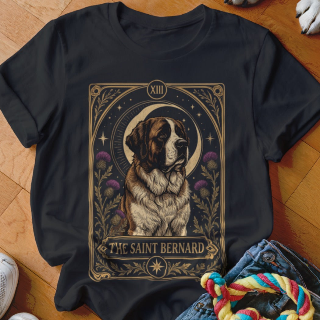 A black t-shirt features a tarot-style graphic of a Saint Bernard framed by purple thistles and a crescent moon.