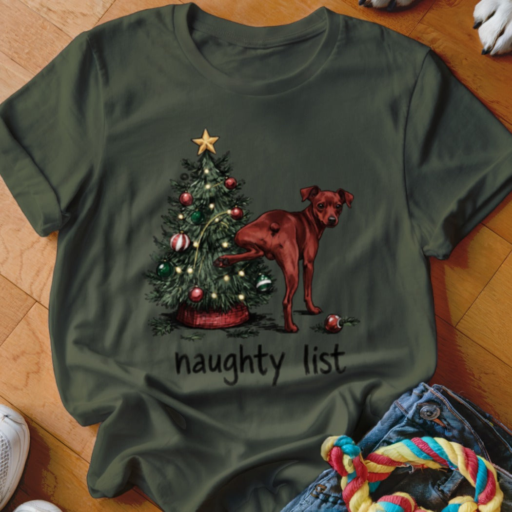 Green t-shirt with a drawing of a dog peeing on a Christmas tree, reads "naughty list".