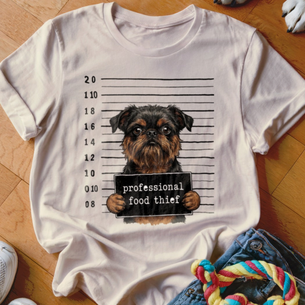 White t-shirt with a cartoon Brussels Griffon dog mugshot and "professional food thief" text.