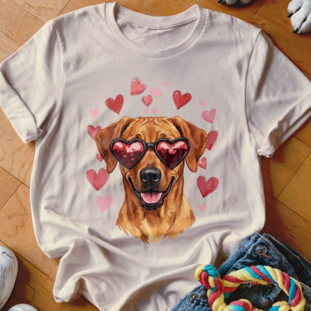 Light-colored crewneck t-shirt featuring a graphic of a golden dog wearing heart-shaped sunglasses, surrounded by pink hearts.