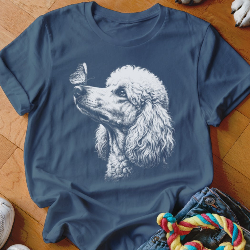Blue crew neck t-shirt featuring a white graphic of a poodle looking at a butterfly.