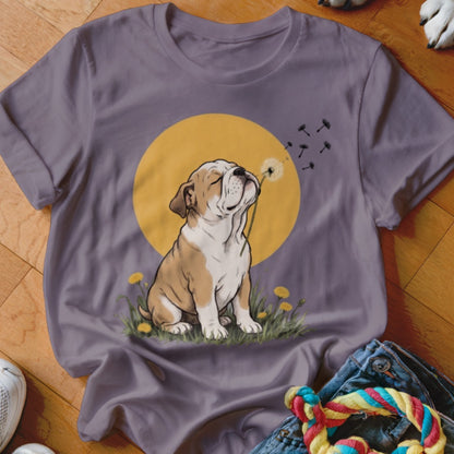 A purple crewneck t-shirt featuring a graphic of a bulldog blowing dandelion seeds against a yellow circle background.