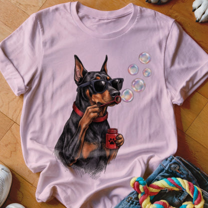 Light pink t-shirt featuring an illustration of a Doberman Pinscher wearing sunglasses and blowing bubbles.