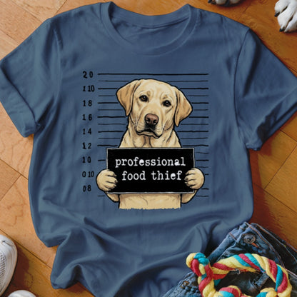 Labrador retriever in mugshot holding "professional food thief" sign.