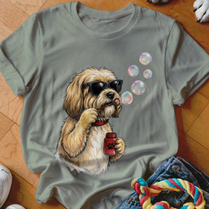 Sage green crewneck t-shirt featuring an illustration of a fluffy dog wearing sunglasses and blowing bubbles.