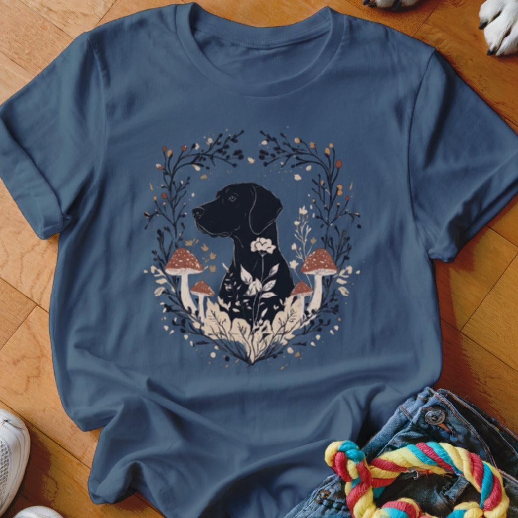 A navy blue t-shirt featuring a black dog graphic surrounded by a botanical wreath of mushrooms and leaves.