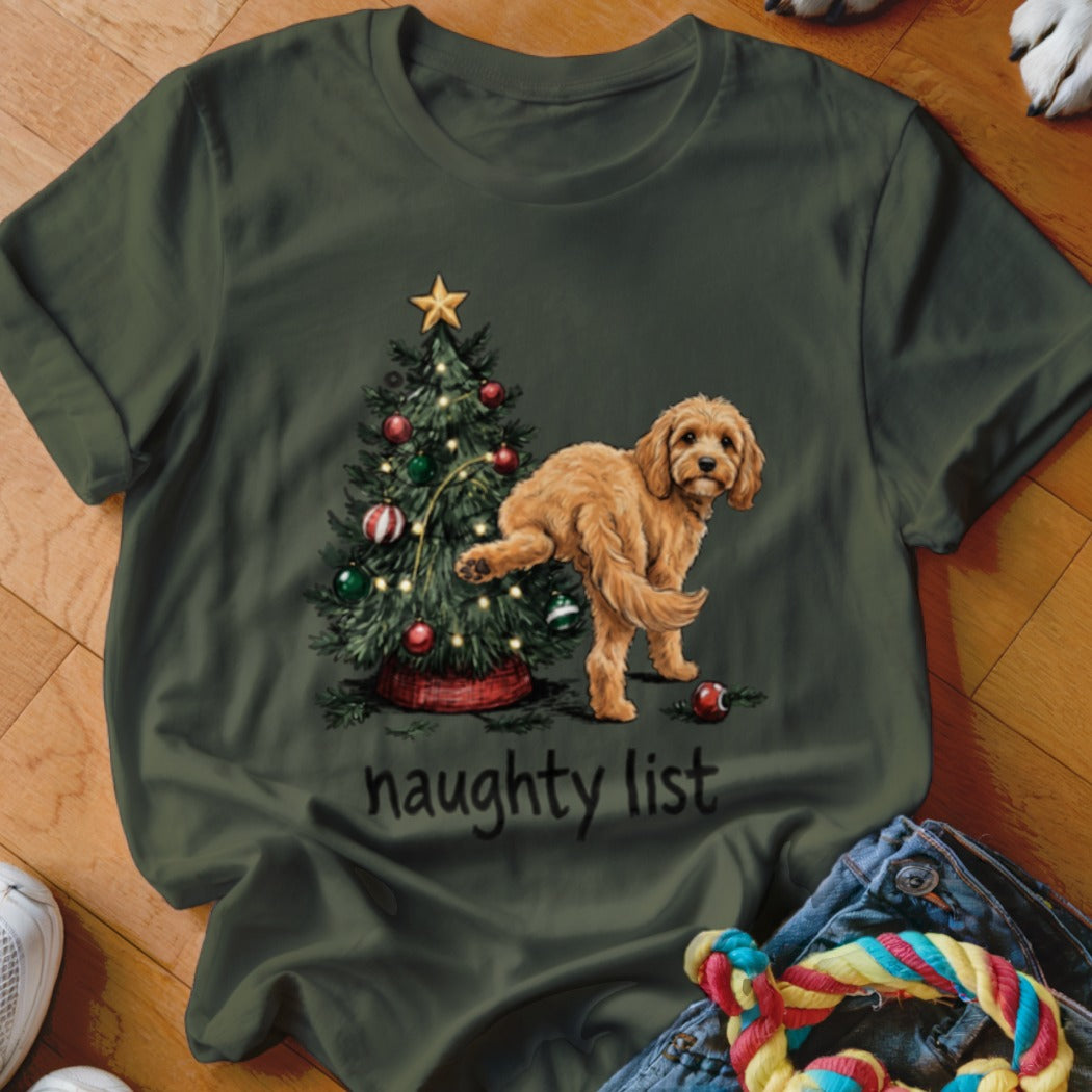Goldendoodle dog with leg raised next to Christmas tree, "naughty list" text.