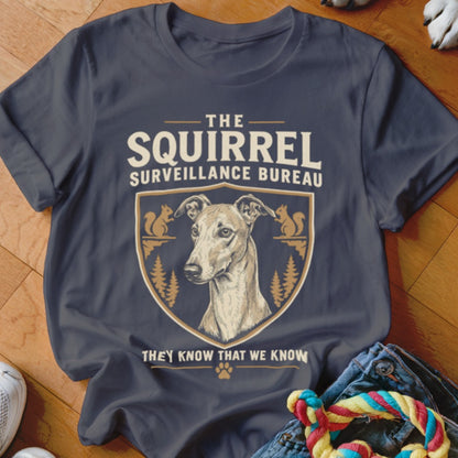 Dark grey t-shirt featuring a graphic with a dog, squirrels, trees, and text reading The Squirrel Surveillance Bureau.
