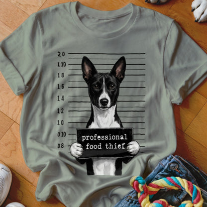 T-shirt graphic of a dog mugshot holding a sign reading "professional food thief".