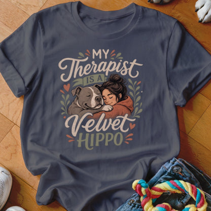 This t-shirt features artwork of a woman hugging a pit bull, with text "My Therapist is a Velvet HIPPO".
