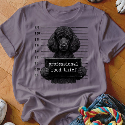 Black poodle holding a "professional food thief" sign against a mugshot background on a t-shirt.