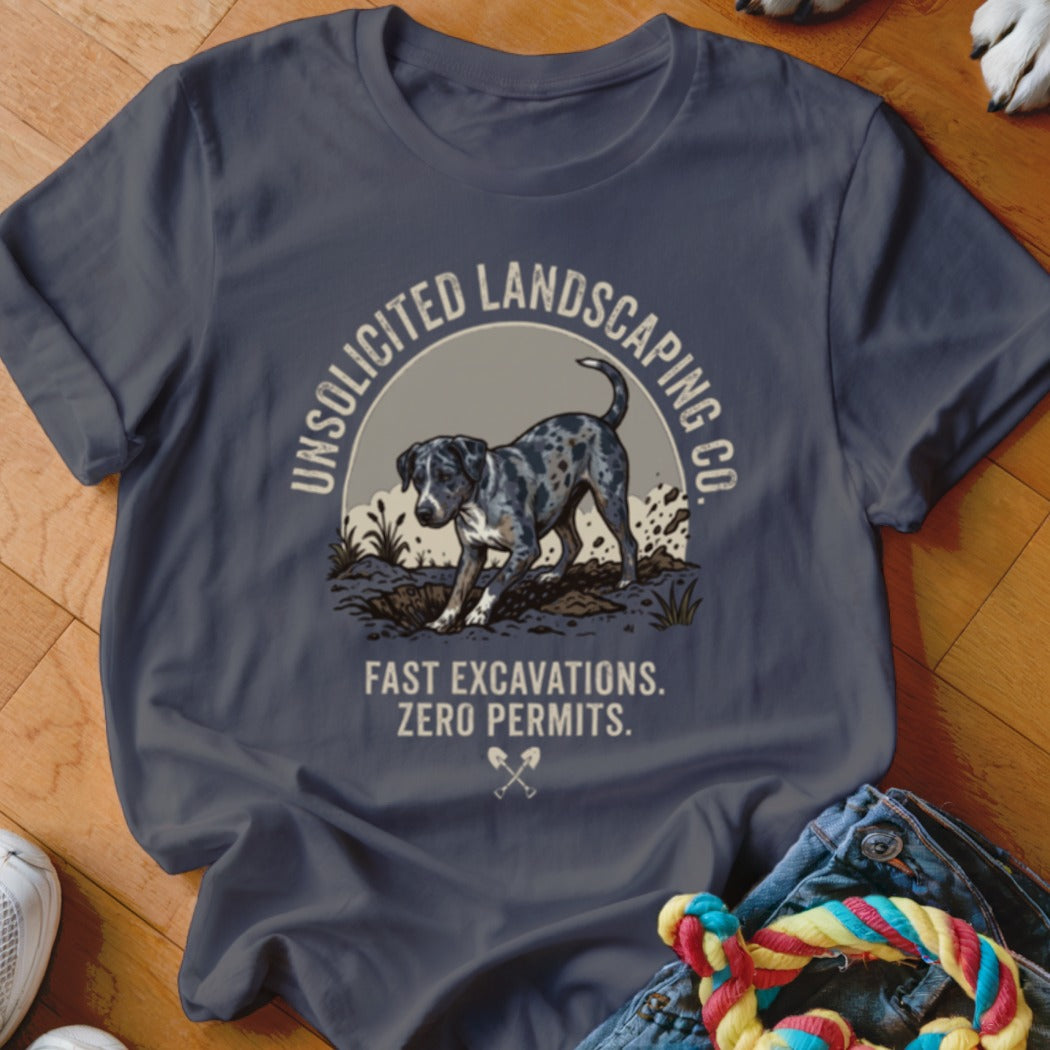 Dark blue t-shirt graphic with a dog digging, "UNSOLICITED LANDSCAPING CO." and "FAST EXCAVATIONS. ZERO PERMITS."