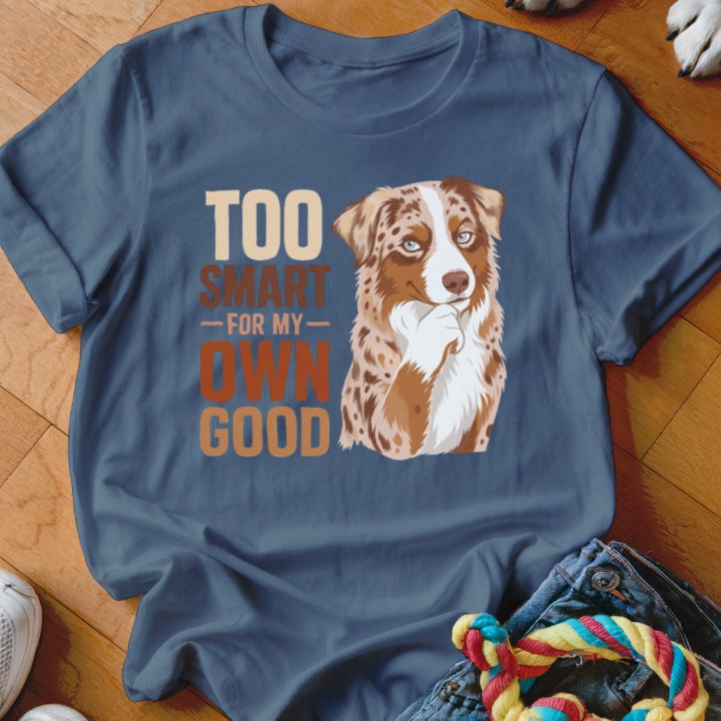 A blue t-shirt printed with a graphic of an Australian Shepherd and text reading Too Smart For My Own Good.