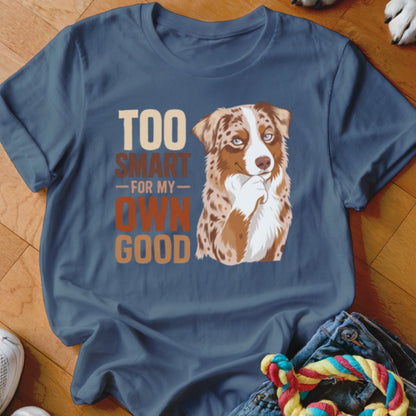 A blue t-shirt printed with a graphic of an Australian Shepherd and text reading Too Smart For My Own Good.