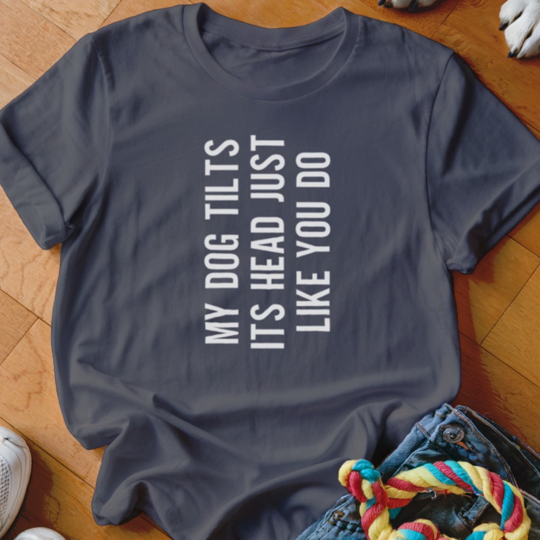 Dark gray t-shirt with white text that reads "MY DOG TILTS ITS HEAD JUST LIKE YOU DO".