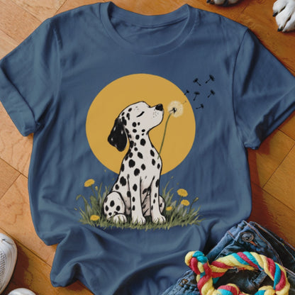 A dark blue t-shirt featuring an illustration of a Dalmatian puppy sitting in grass and blowing dandelion seeds.